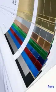 Stalenwaaier met luxe foliedruk in goud, zilver, rood, blauw, groen en zwart, voorbeeld van premium boekafwerking met Boekenmakers-logo rechtsonder.