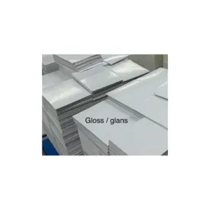 Stapels glanzend gestreken papier (gloss MC), klaar voor verwerking tot covers of pagina’s. 
