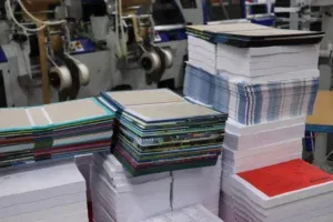 Gestapelde boekomslagen en binnenwerken in een print-on-demand drukkerij 