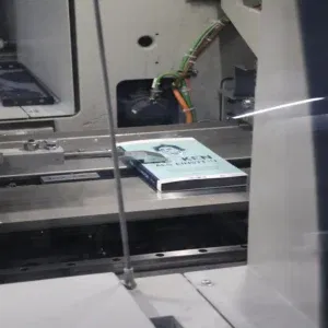 Professioneel boek drukken op industriële printer – close-up van een boek in het productieproces.