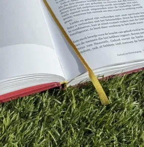 Openliggend boek met geel leeslint op gras – stijlvolle bladwijzer in luxe uitgave 