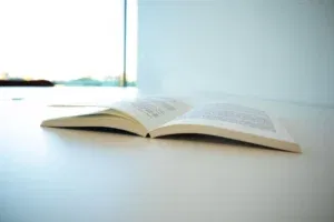 Openliggend roman boek op tafel in modern, licht interieur.