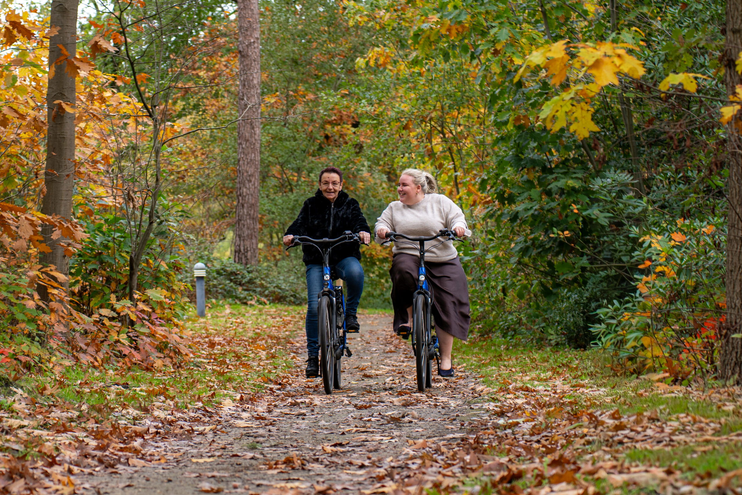 Twee dames aan het fietsen door het bos
