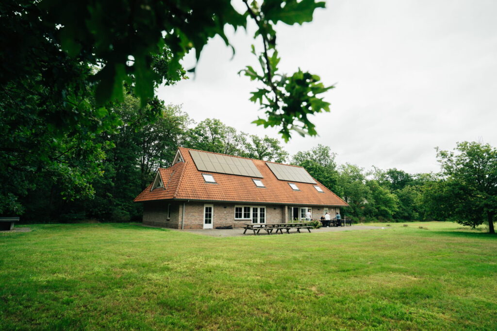 Groepsaccommodatie van Buitengoed Fredeshiem met groot grasveld in een bosrijke omgeving.