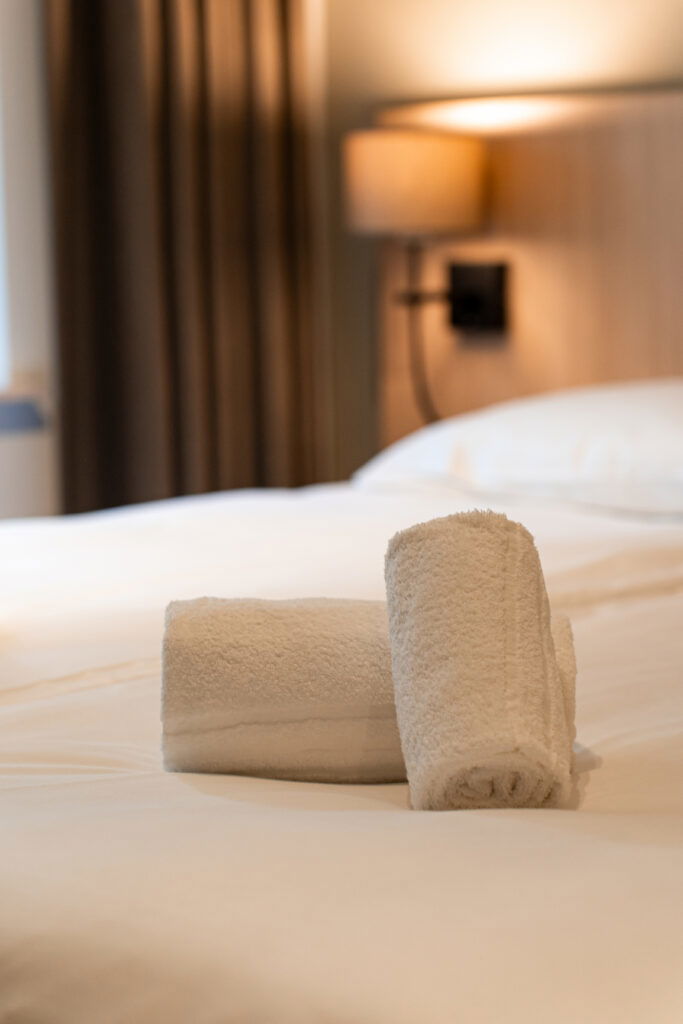 Twee handdoeken netjes opgerold op een prachtige kamer bij Buitengoed Fredeshiem