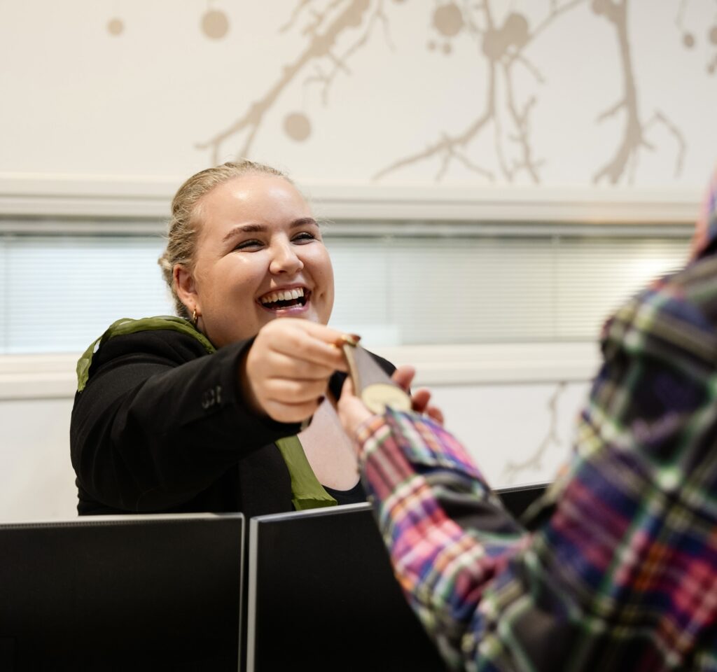 De receptioniste checkt gasten in en geeft de sleutel