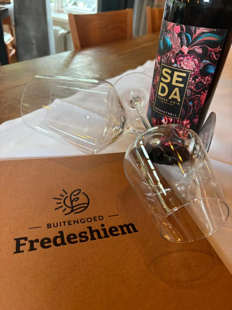 Nieuwe zomerkaart 2026 van restaurant Buitengoed Fredeshiem met wijn en wijnglazen op tafel