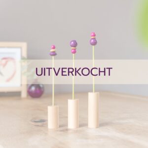 houten bloemetjes paars fuchsia in houten voetje op tafel