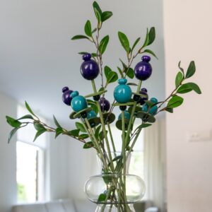 Houten boeket met groene stelen en donker paarsblauw en petrolkleurige houten bloemen