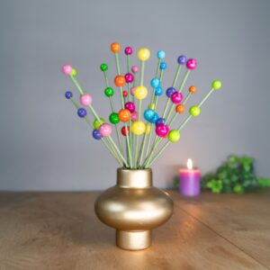 houten bloemetjes, groene steeltjes met bolletjes in de kleuren van de regenboog